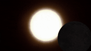 What causes a total solar eclipse and how often do they occur?