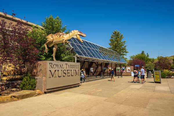 Drumheller, Alberta: Visitors at the front entrance of the Royal Tyrrell Museum of Palaeontology in Alberta with a dinosaur sculpture in the foreground