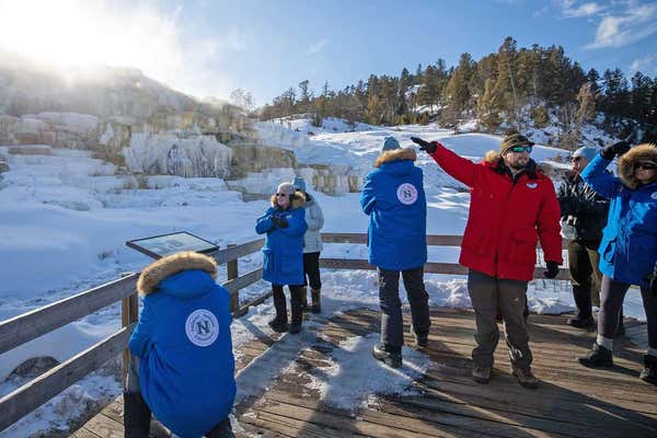 Guests from a Natural Habitat trip in Yellowstone admiring view of geology in park.
