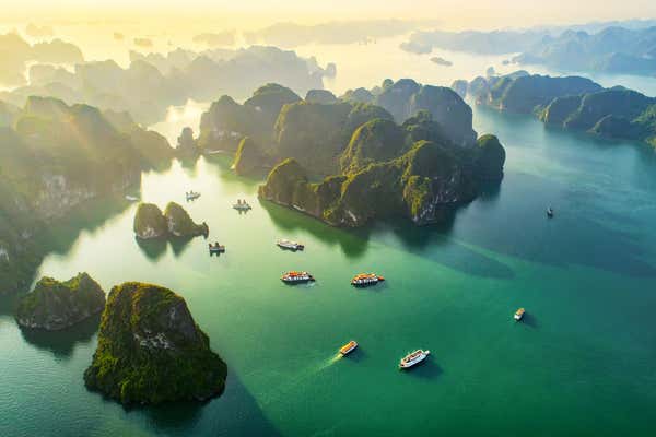 Aerial view floating fishing village and rock island, Halong Bay, Vietnam, Southeast Asia. UNESCO World Heritage Site. Junk boat cruise to Ha Long Bay. Popular landmark, famous destination of Vietnam